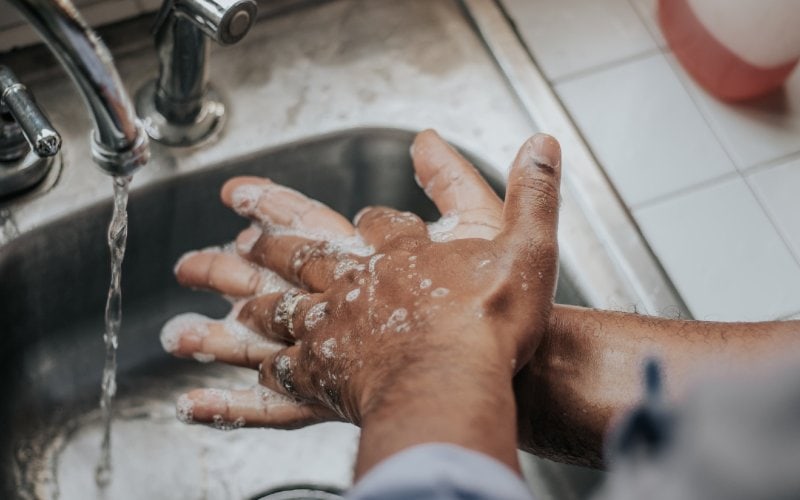 uomo che si lava le mani nel lavandino